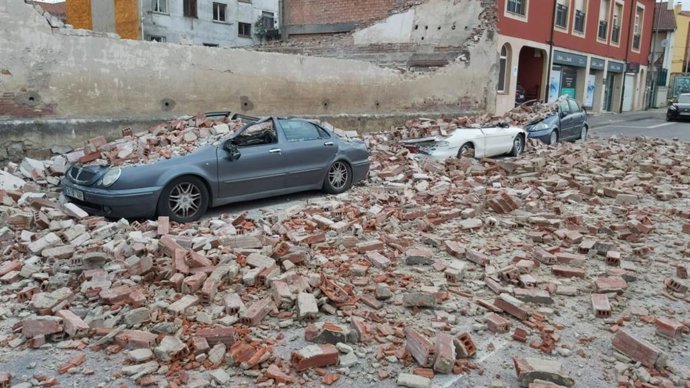 Vehículos dañados por un muro derribado por  la borrasca 'Bella'