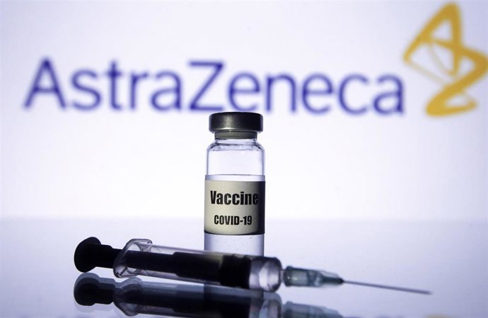 Vial y jeringuilla delante del logotipo de la farmacéutica AstraZeneca