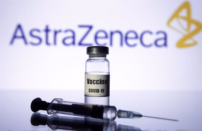 21 November 2020, Ukraine, ---: A medical syringe and an a vial written on it coronavirus (COVID-19) vaccine  are pictured in front of the AstraZeneca biopharmaceutical company logo. Pharmaceutical giant AstraZeneca and the University of Oxford on Monda