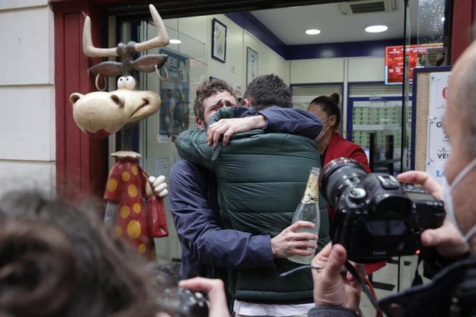 Clientes y loteros de la administración de lotería situada en la Calle Comercio, 21, en la que se ha repartido parte del número 52472 correspondiente al Tercer Premio del Sorteo Extraordinario de Lotería de Navidad 2020, en Toledo