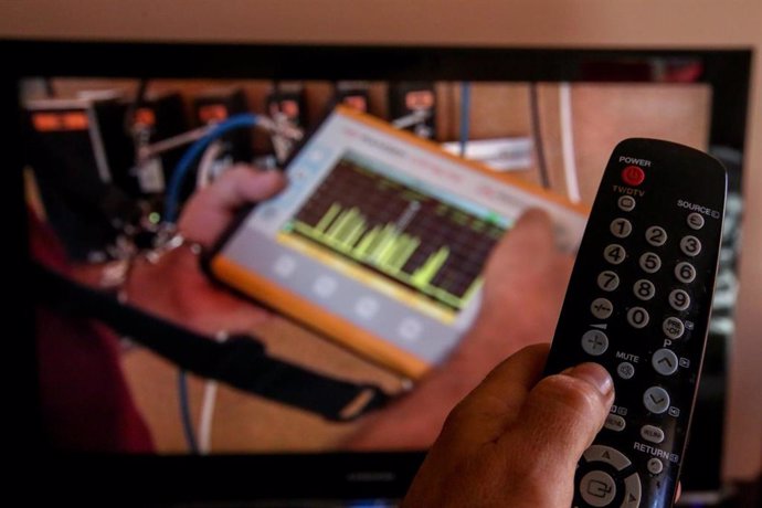 Una persona utiliza su mando de la televisión para buscar canales, en Madrid