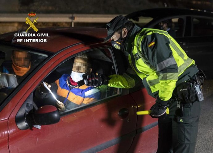 Un agente de la Guardia Civil realiza una prueba de alcoholemia a un conductor