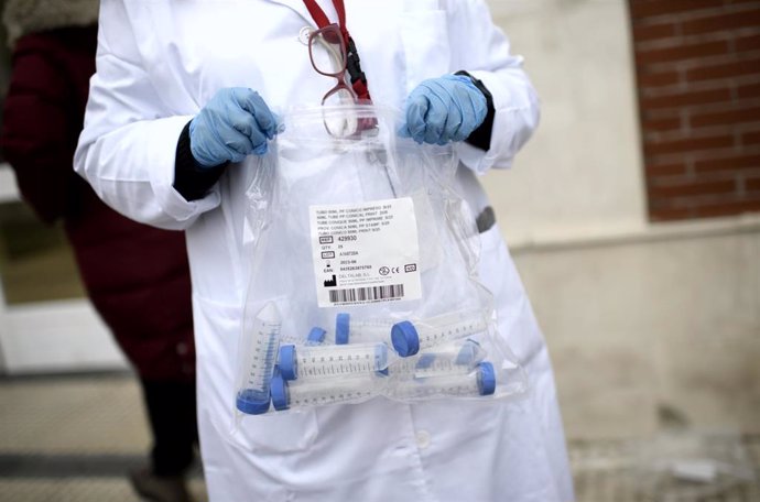 Un sanitario con tubos de ensayo durante la realización de tests de RT-PCR en saliva en el Colegio Internacional Alameda de Osuna, en Madrid.