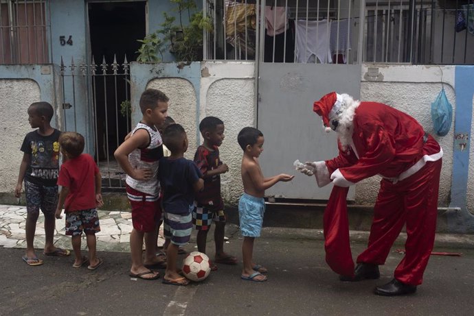 Papá Noel distribuye gel hidroalcohólico a unos niños en la favela Mare, en Río de Janeiro.
