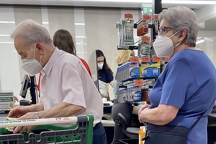 Una pareja de pensionistas compra en un supermercado