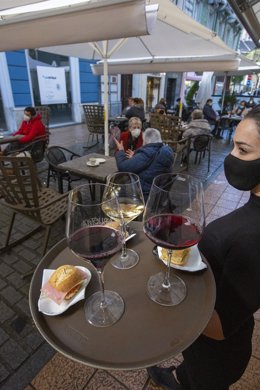 Una camarera se dispone a servir en una terraza de un restaurante de Avilés, Asturias (España), a 14 de diciembre de 2020.