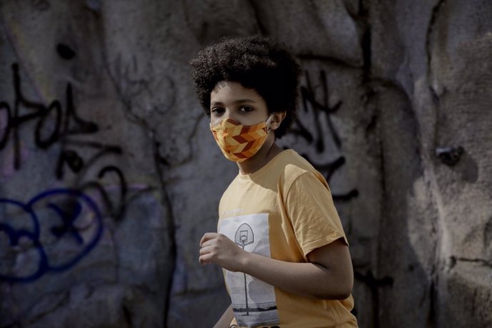 El niño actor y modelo Hugo Ndiaye, de 10 años, pasea el primer día en el que los menores de 14 años de la Comunidad de Madrid pueden realizar paseos entre las 10 y las 13 horas y entre las 17 y las 21 horas, tras decidir la Comunidad de Madrid flexibil