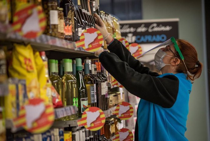 Trabajadora de un supermercado catalán reponiendo productos