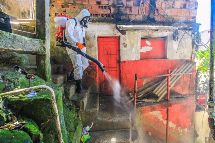 Una persona desinfecta una favela en Río de Janeiro.