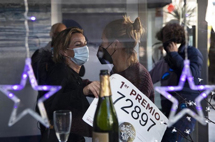 Lotera celebra `El Gordo con un abrazo en la administración de lotería situada en la Avenida de Andalucía en la que se ha repartido parte del número `72.897 correspondiente a 'El Gordo' de la Lotería de Navidad. Punta Umbría, Huelva, Andalucía, España a