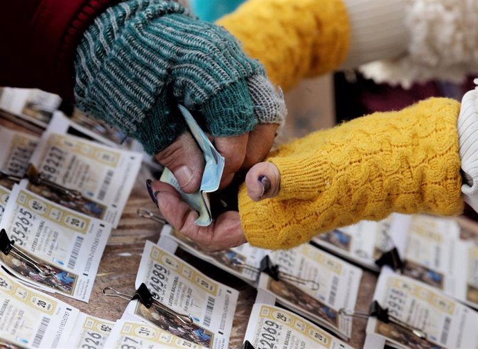 Una mujer comprando un boleto de la Lotería del Niño