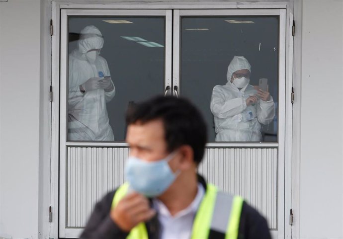 Trabajadores con trajes protectores en Tailandia.