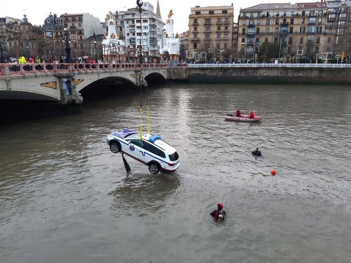 Izado del vehículo de la Ertzaintza caído al río Urumea, en San Sebastián, donde ha fallecido un ertzaina y otro ha resultado herido