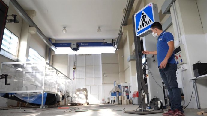 Un trabajador de Interlight junto a uno de los sistemas inteligentes de señalización vial