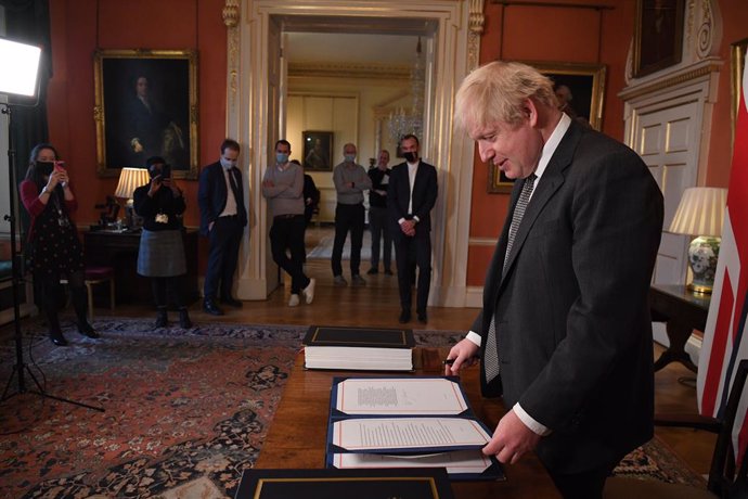 30 December 2020, England, London: UK Prime Minister Boris Johnson prepares to sign the EU-UK Trade and Cooperation Agreement at 10 Downing Street. Photo: Leon Neal/PA Wire/dpa
