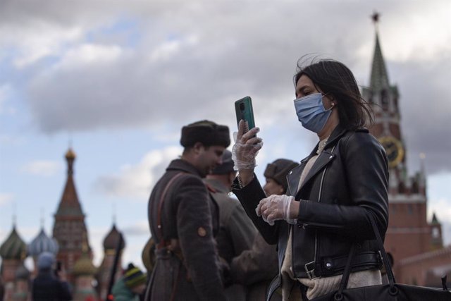 Una mujer con mascarilla se fotografía en la Plaza Roja de Moscú