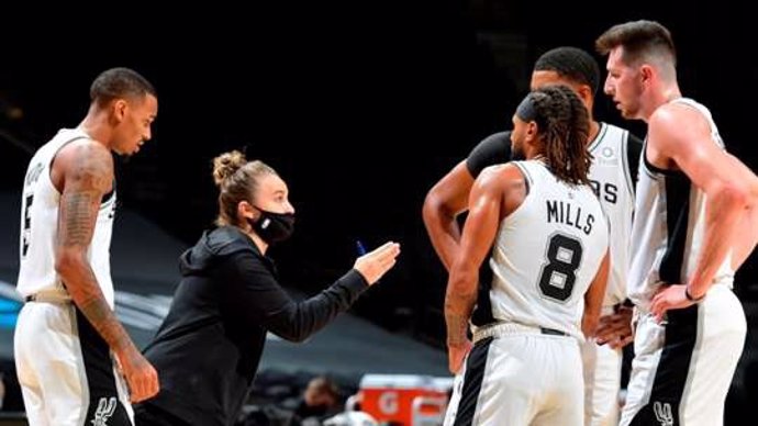 Becky Hammon da instrucciones a los jugadores de los Spurs