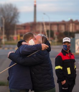 El presidente del comité de empresa de Alcoa San Cibrao, José Antonio Zan, abraza a un trabajador jubilado tras conocer la anulación  del ERE de la empresa, en Cervo (Lugo)