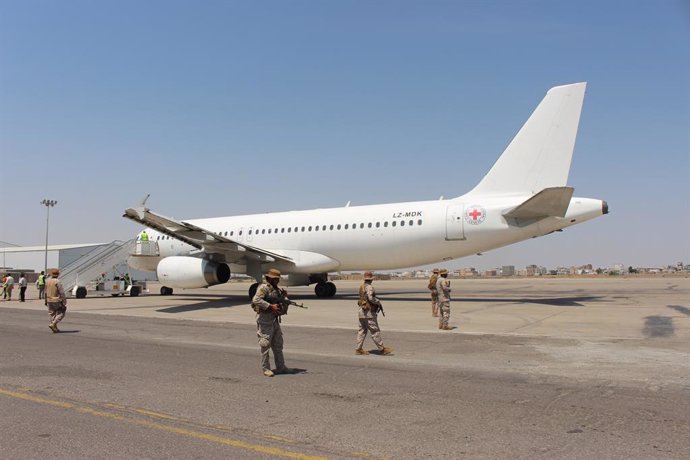 16 October 2020, Yemen, Aden: Saudi soldiers stand guard of a plane used by International Red Cross, carrying Yemeni prisoners who were held by Houthi upon their arrival at an airport in the southern city of Aden, on the second day of a prisoner swap be