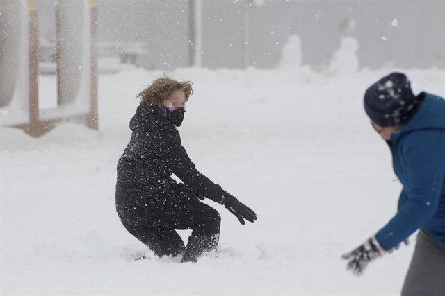 Dos niños disfrutan de la nieve 