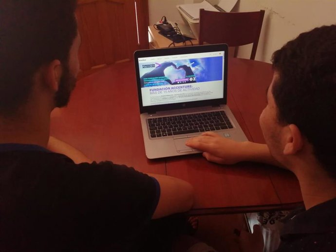 Dos jóvenes de la Asociación Arrabal-AID con uno de los portátiles.