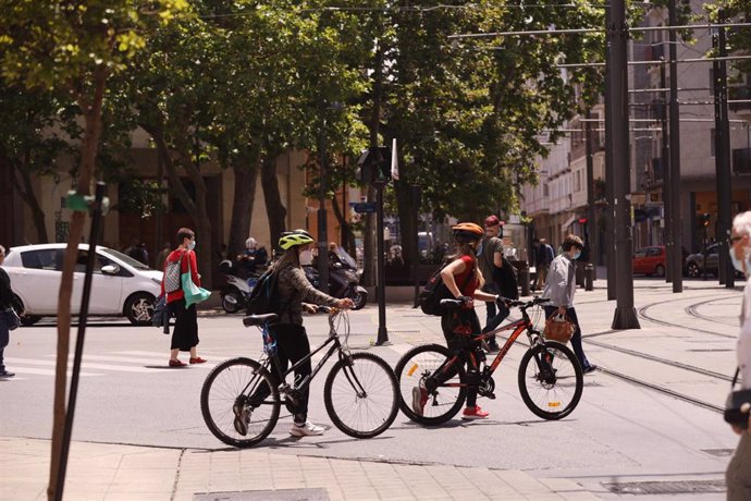 Jóvenes con mascarilla pasean con bicicleta por una céntrica calle de Vitoria-Gasteiz, Álava, País Vasco (España), a 16 de julio de 2020. 