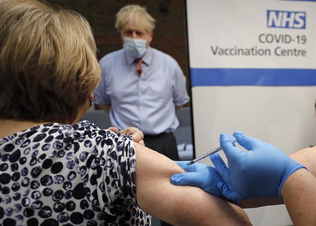 El primer ministro, Boris Johnson, ve cómo se vacuna a una mujer contra la COVID-19