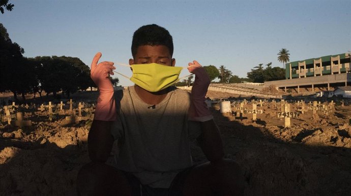 Un joven trabajador de un cementerio de Río de Janeiro trabaja en el mantenimiento y desinfección de las lápidas para evitar posibles infecciones de coronavirus.