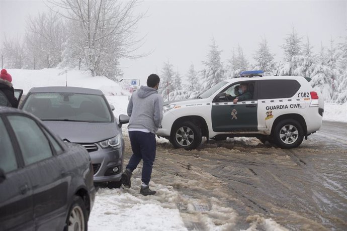 Un coche de la Guardia Civil da instrucciones sobre aparcamiento en la parroquia de O Cebreiro, en Lugo, Galicia (España), a 29 de diciembre de 2020. El temporal de nieve ha dificultado la circulación en más de un centenar de carreteras en las provincia