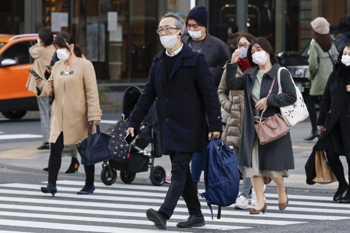 16 December 2020, Japan, Tokyo: People wearing face masks walk around the Ginza shopping district. Tokyo reached a new single-day record of 678 new coronavirus (COVID-19) cases on Wednesday. Photo: Rodrigo Reyes Marin/ZUMA Wire/dpa