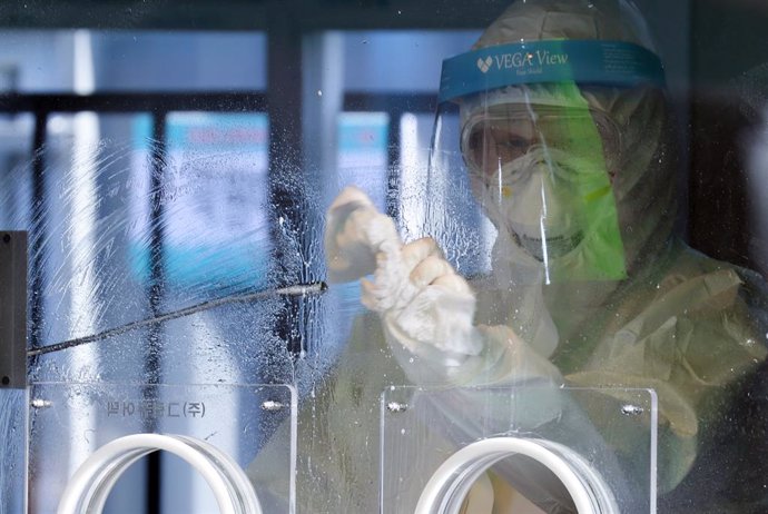 02 January 2021, South Korea, Seoul: A health worker disinfects a testing facility set up in front of Seoul station after conducting a coronavirus test. Photo: -/YNA/dpa