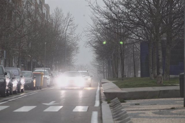 Un coche circula por una de las calzadas de la ciudad con las luces antiniebla encendidas debido a la niebla 