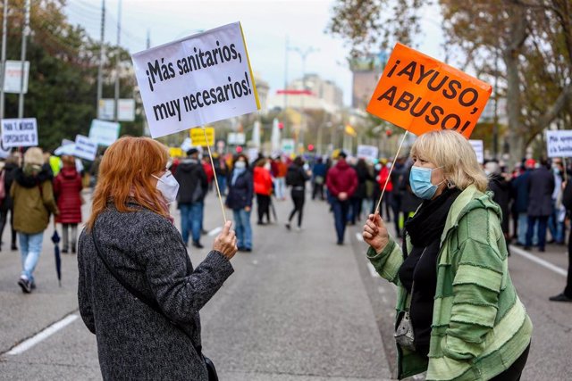 Una mujer sostiene una pancarta donde se lee "¡Más sanitarios, muy necesarios!" durante una manifestación de la Marea Blanca en Madrid.