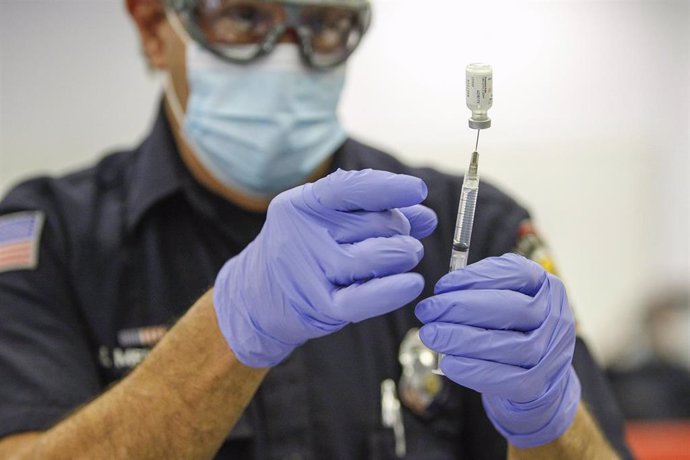 Un sanitario preparara una dosis de la vacuna de Pfizer en San Diego, Estados Unidos