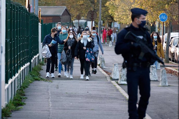 03 November 2020, France, Conflans-Sainte-Honorine: A CRS officer stands near the entrance of Le Bois d'Aulne middle school as the pupils are back to school after the holiday they took for two weeks following the killing of the French teacher Samuel Pat