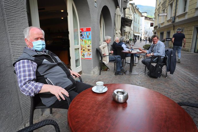 03 June 2020, Italy, Brixen: Aman wearing a face mask sits in a street cafe in the old town in Brixen. Italy on Wednesday reopened its borders to visitors from the rest of the European Union and dropped a ban on travel between its regions as part of th