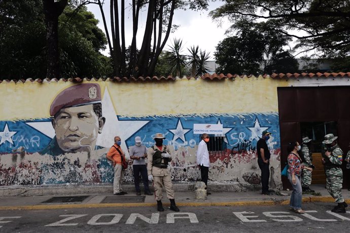 06 December 2020, Venezuela, Caracas: A queue of voters waits in front of a polling station during the 2020 Venezuelan parliamentary election. Most opposition parties as well as interim president Guaido expect electoral fraud and have therefore called f