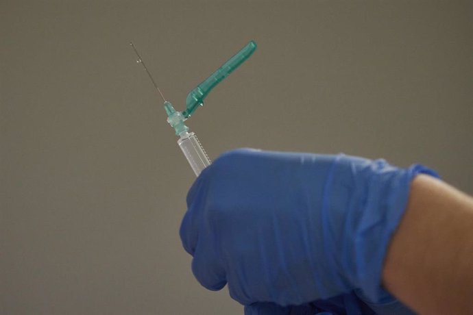 Una trabajadora sanitaria manipula el material necesario para administrar la vacuna contra la COVID-19 en un espacio de Refena,