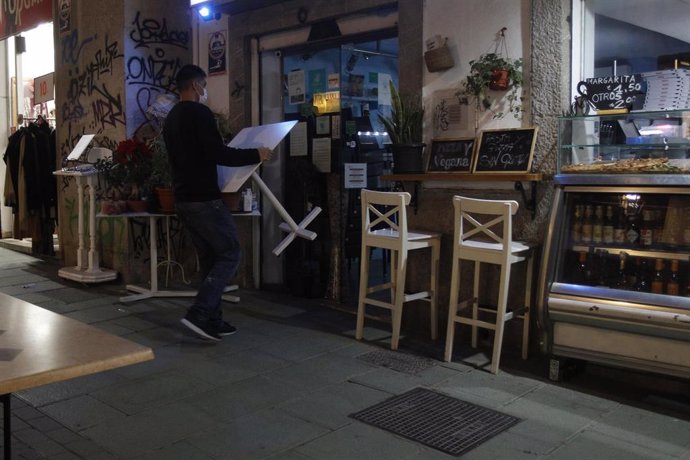 Un camarero recoge las mesas de la terraza de una cafetería en Palma antes de las 18.00 horas.