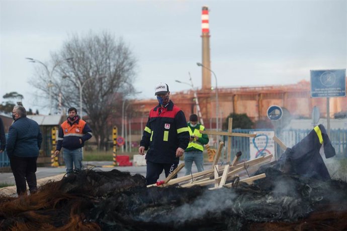 Trabajadores de Alcoa San Cibrao celebran la anulación del TSXG del ERE de la empresa y queman las cruces del velatorio simbólico que semanas atrás habían instalado en el recinto de la fábrica, en Cervo, A Mariña, Lugo, Galicia (España), a 17 de diciemb