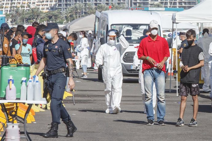 Un policía nacional, en primer plano en el muelle de Arguineguin donde fueron atendidos los migrantes que llegaban a las islas