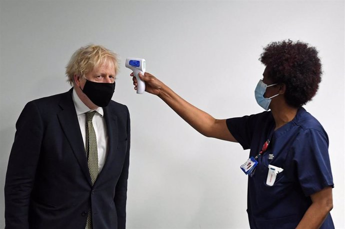 Una sanitaria toma la temperatura al primer ministro británico, Boris Johnson