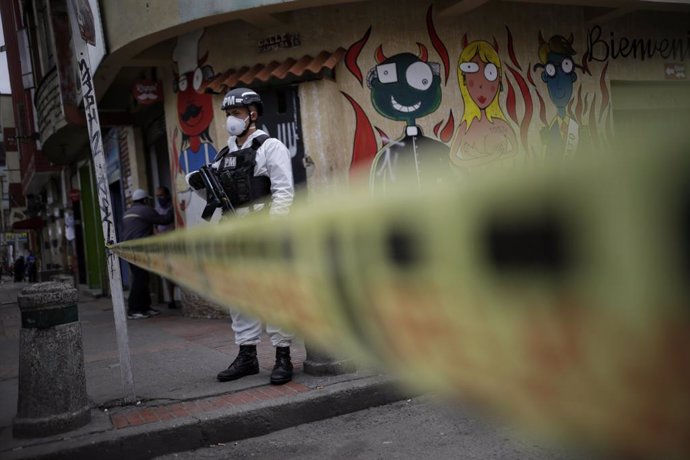 13 July 2020, Colombia, Bogota: A Colombian police member wears protective suits as he stands guard during a curfew imposed to curb the spreading of coronavirus. Photo: Sergio Acero/colprensa/dpa