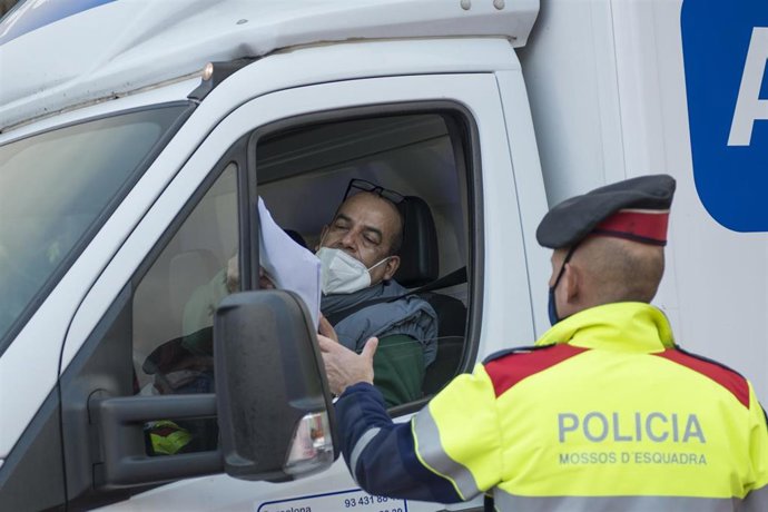 Un Mosso d'Esquadra pide documentación a un conductor durante el control policial por el confinamiento perimetral en la C-17 a la entrada de Ripoll, en Girona (España), a 24 de diciembre de 2020. 