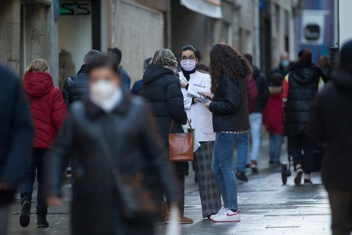 Gente paseando y conversando en el centro de una ciudad.