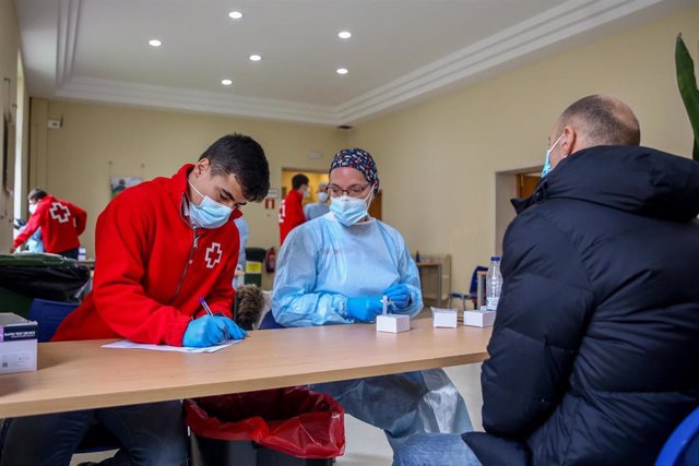 Un trabajador de Cruz Roja, una sanitaria y un hombre en un dispositivo para la realización de test de antígenos 