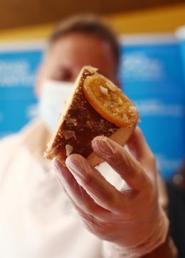 Un repostero sostiene un trozo de un roscón de reyes