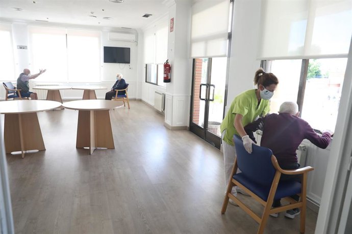 Una gerocultura ayuda a levantarse a un residente, foto de recurso