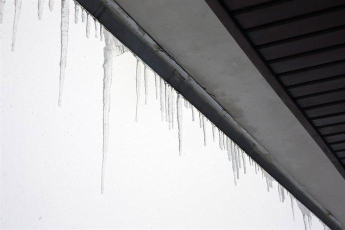 El frio forma estalactitas de hielo en un tejado de una vivienda de Pajares, Asturias. 