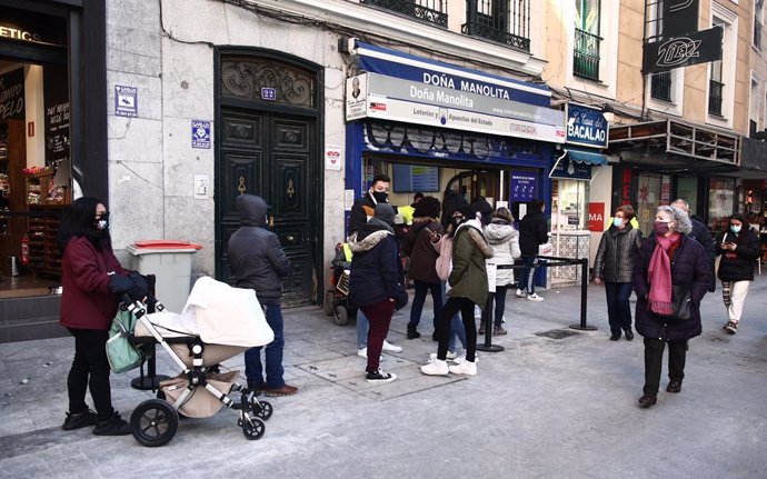 Diverses persones fan cua davant l'administració de loteria Doña Manolita, a Madrid (Espanya), 5 de gener del 2021